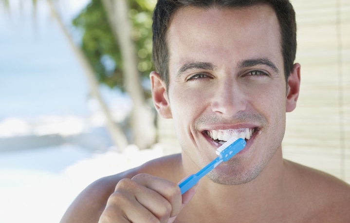 man brushes teeth toothbrush tooth paste