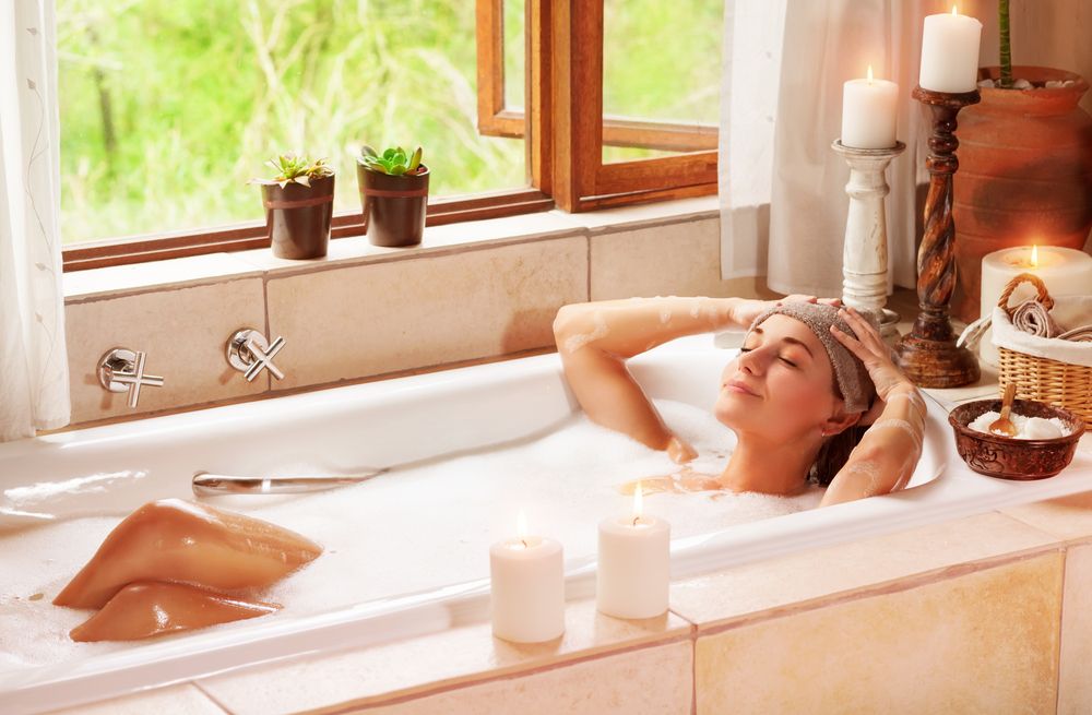 Woman relaxing at spa resort lying down in the bath