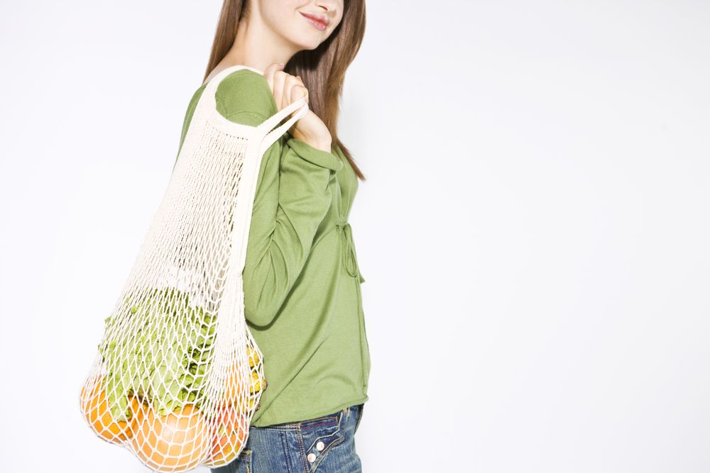 young-woman-carrying-vegetables-in-a-shopping-bag